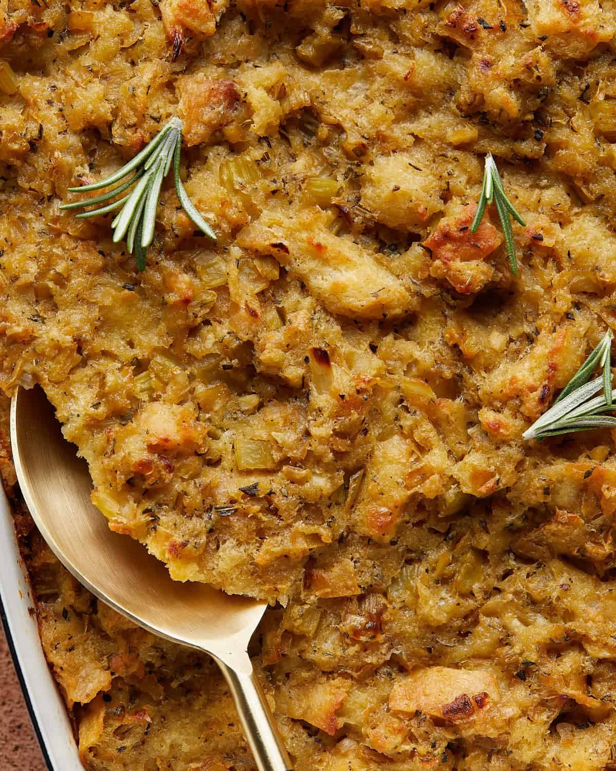 Up close image of homemade make ahead stuffing with golden toasted bread, tender vegetables, and fresh herbs, highlighting the crispy top.