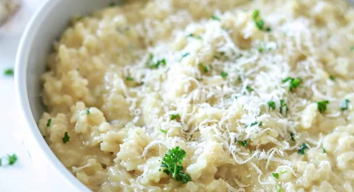 Overhead image of creamy garlic parmesan risotto with garnish.