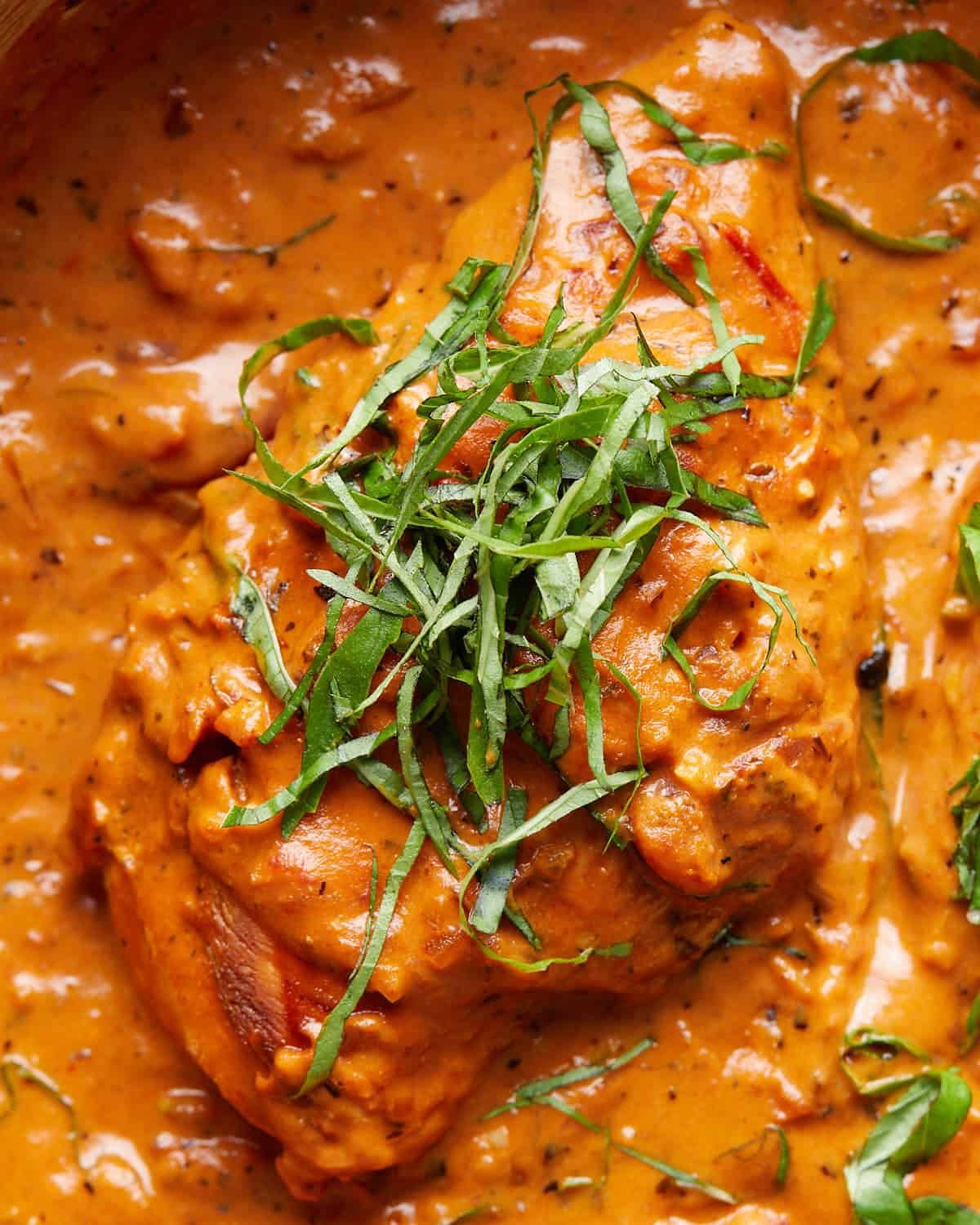 Up close image of tomato basil chicken with garnish.