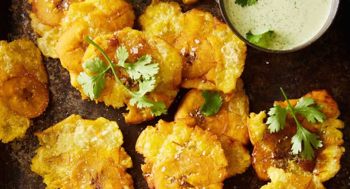 Overhead image of tostones with cilantro-jalapeno green sauce.