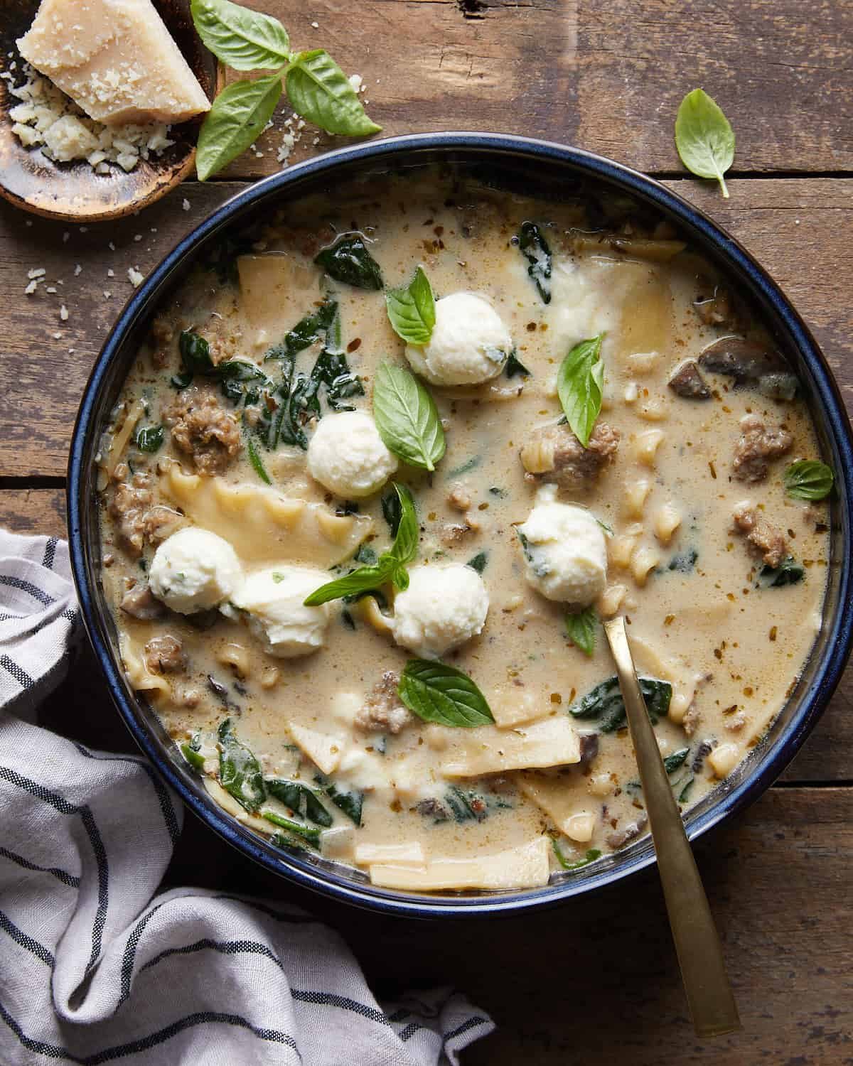Overhead image of white lasagna soup with garnish.