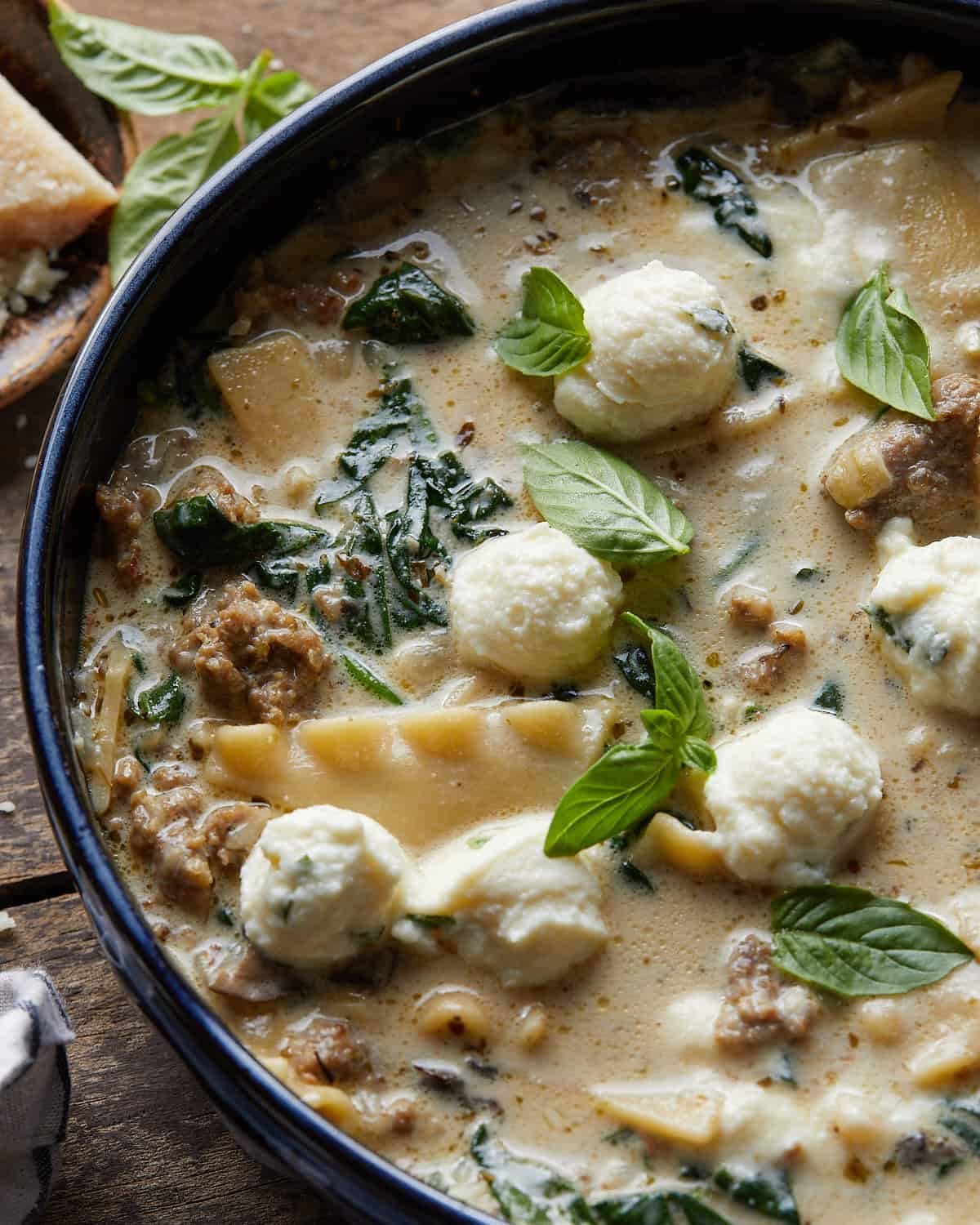 Up close overhead image of white lasagna soup with garnish.