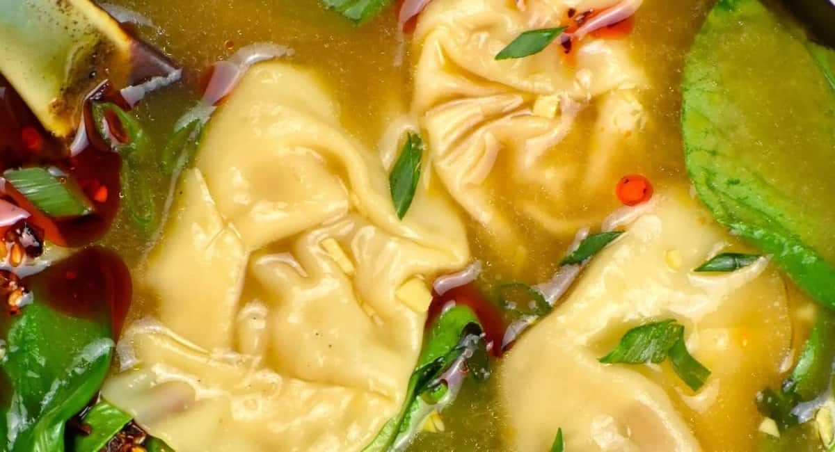 Overhead image of wonton soup with garnish.