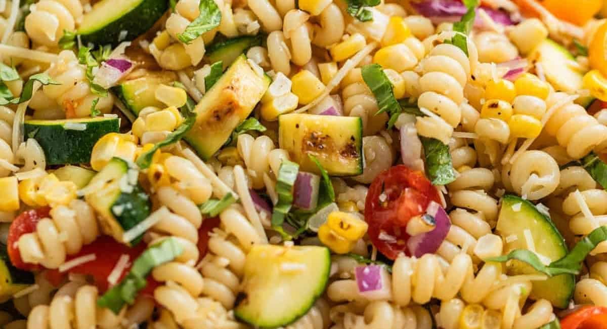 Up close image of grilled zucchini pasta salad with garnish.