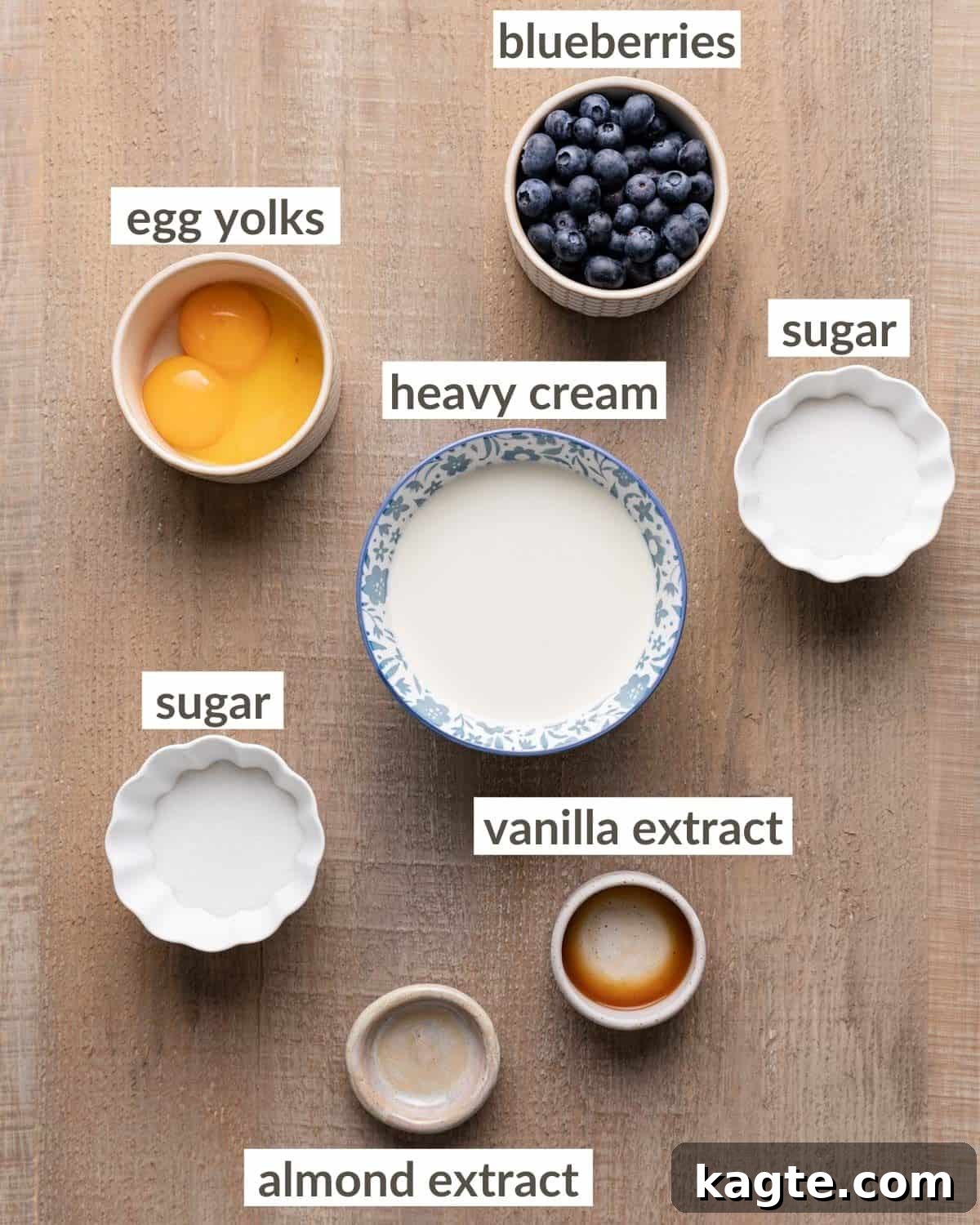 Double Delight Blueberry Crème Brûlée 3 Overhead shot of all ingredients laid out for Blueberry Crème Brûlée, including fresh blueberries, heavy cream, eggs, sugar, vanilla extract, and almond extract.