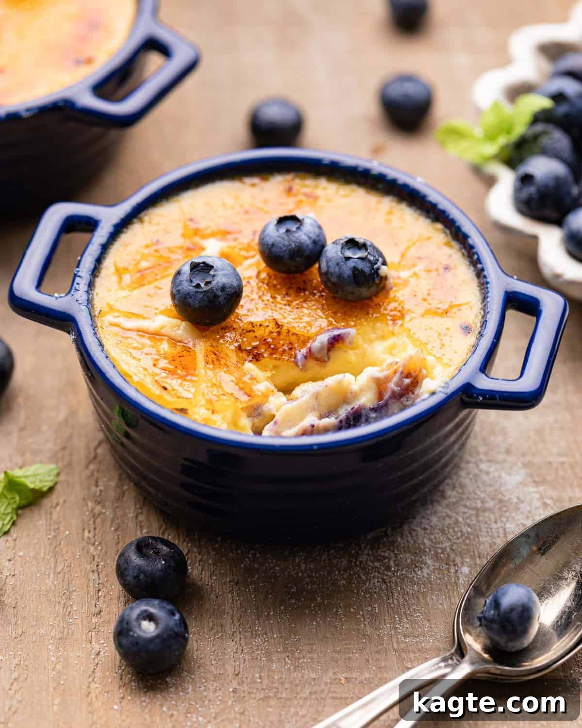 Double Delight Blueberry Crème Brûlée 9 Close-up side view of a single Blueberry Crème Brûlée in a ramekin, showing the distinct layers of blueberry sauce, creamy custard, and crispy torched sugar topping.
