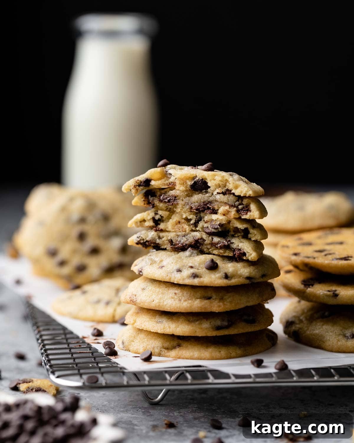 A side view of a perfectly baked stack of golden chocolate chip cookies, showcasing their inviting texture and generous chocolate content.