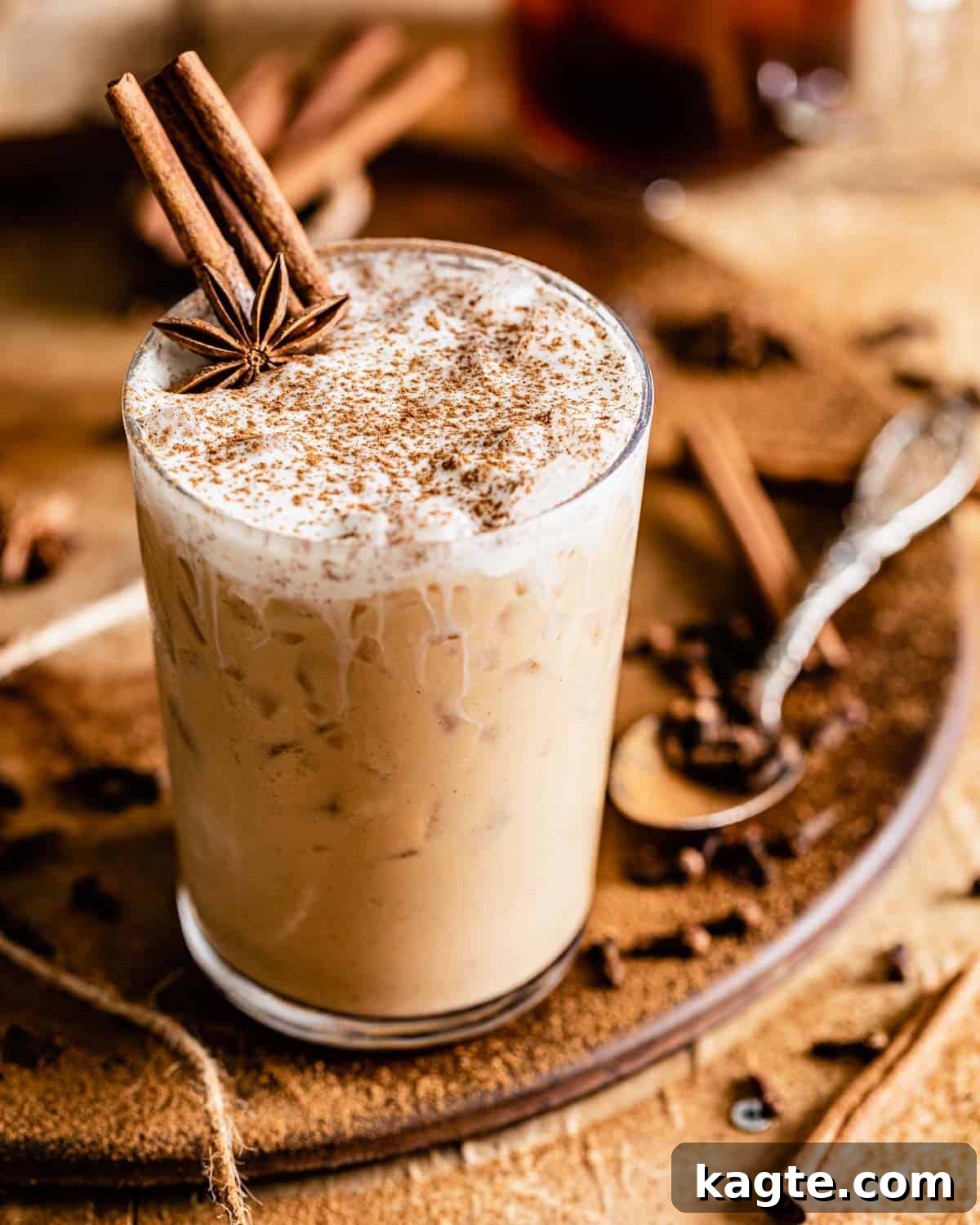Craft Your Own Starbucks Chai Tea Latte 6 iced chai latte with whipped cream and cinnamon on top in a clear glass