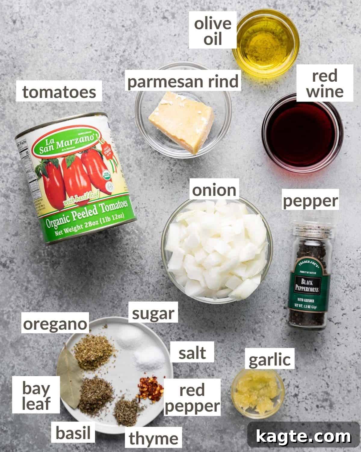 Overhead view of fresh ingredients laid out for making marinara sauce, including tomatoes, garlic, onions, and herbs.