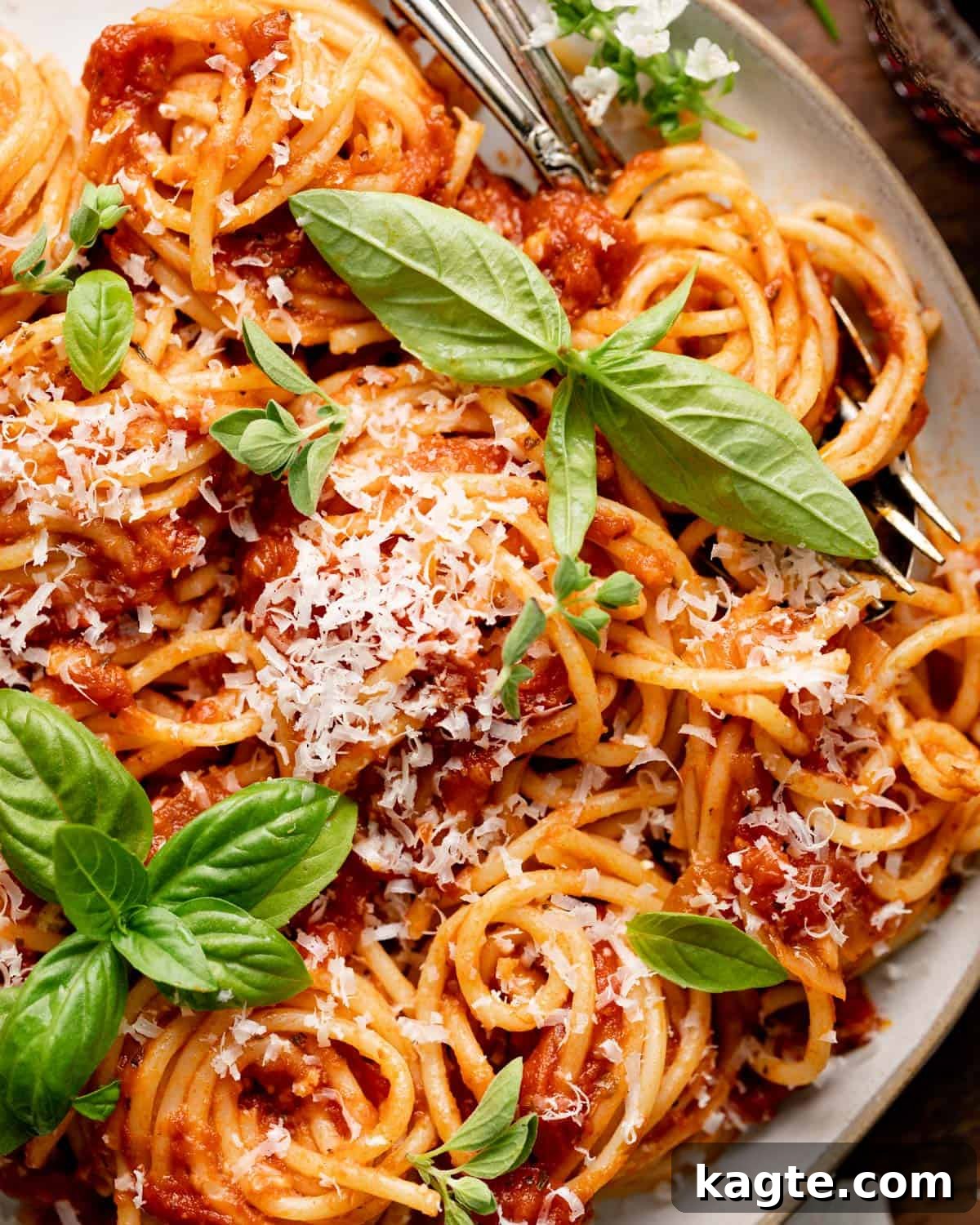 Close-up of spaghetti coated in a rich, hearty marinara sauce, garnished with fresh basil.