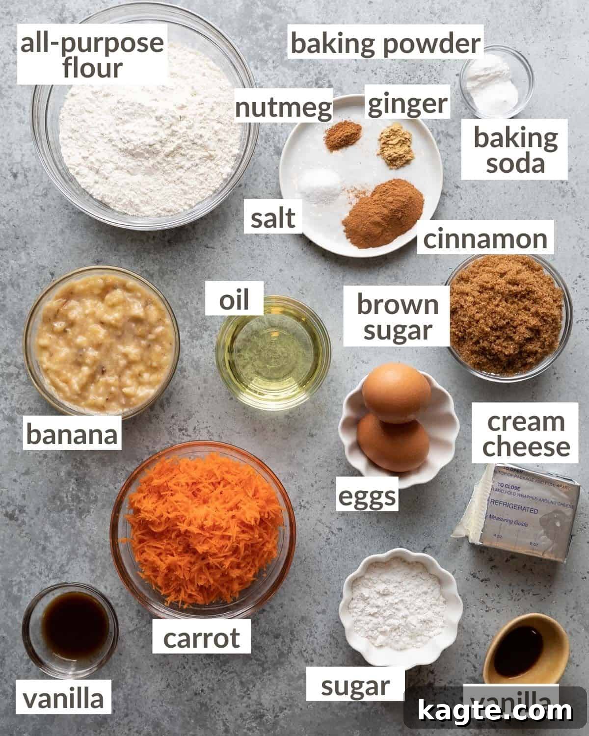 Garden Patch Banana Carrot Muffins 3 Overhead view of all ingredients for banana carrot muffins laid out on a baking surface: flour, sugar, spices, eggs, bananas, carrots, oil, and cream cheese.