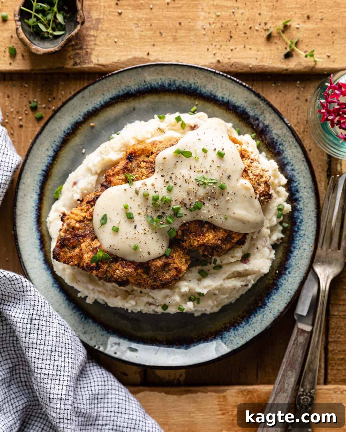 Crispy Air Fryer Chicken Fried Steak 2 Air fryer chicken fried steak on a bed of mashed potatoes, generously topped with creamy white gravy.