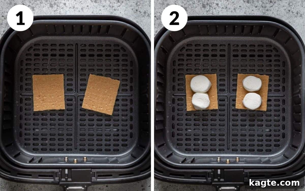 Gooey Air Fryer S'mores 4 Air fryer basket prepped with graham crackers and marshmallow halves, ready for cooking.