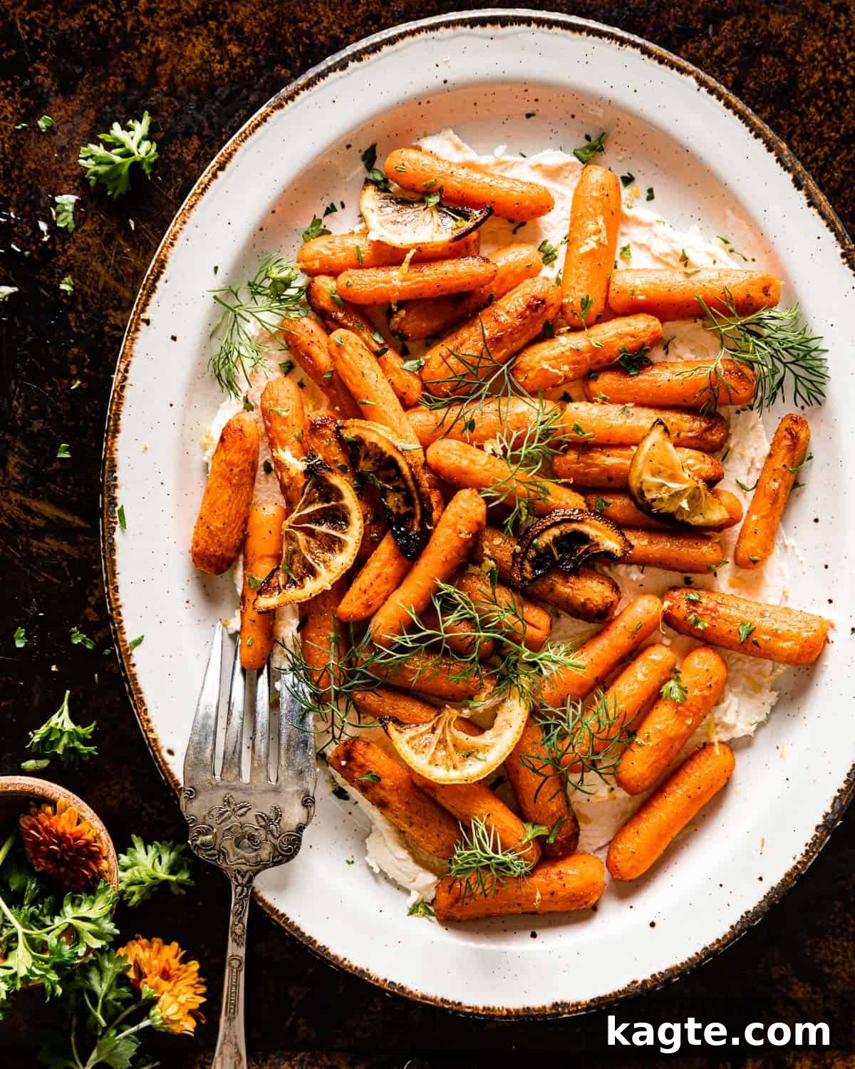 Overhead view of perfectly roasted air fryer baby carrots served over creamy whipped feta and garnished with fresh dill, ready to be enjoyed.