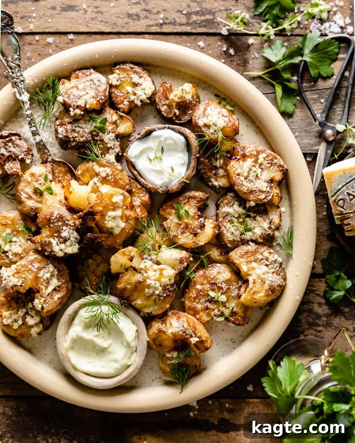 Golden Smashed Air Fryer Potatoes 2 Overhead shot of perfectly golden and crispy air fryer smashed potatoes on a plate, garnished with fresh herbs and a sprinkle of parmesan cheese.