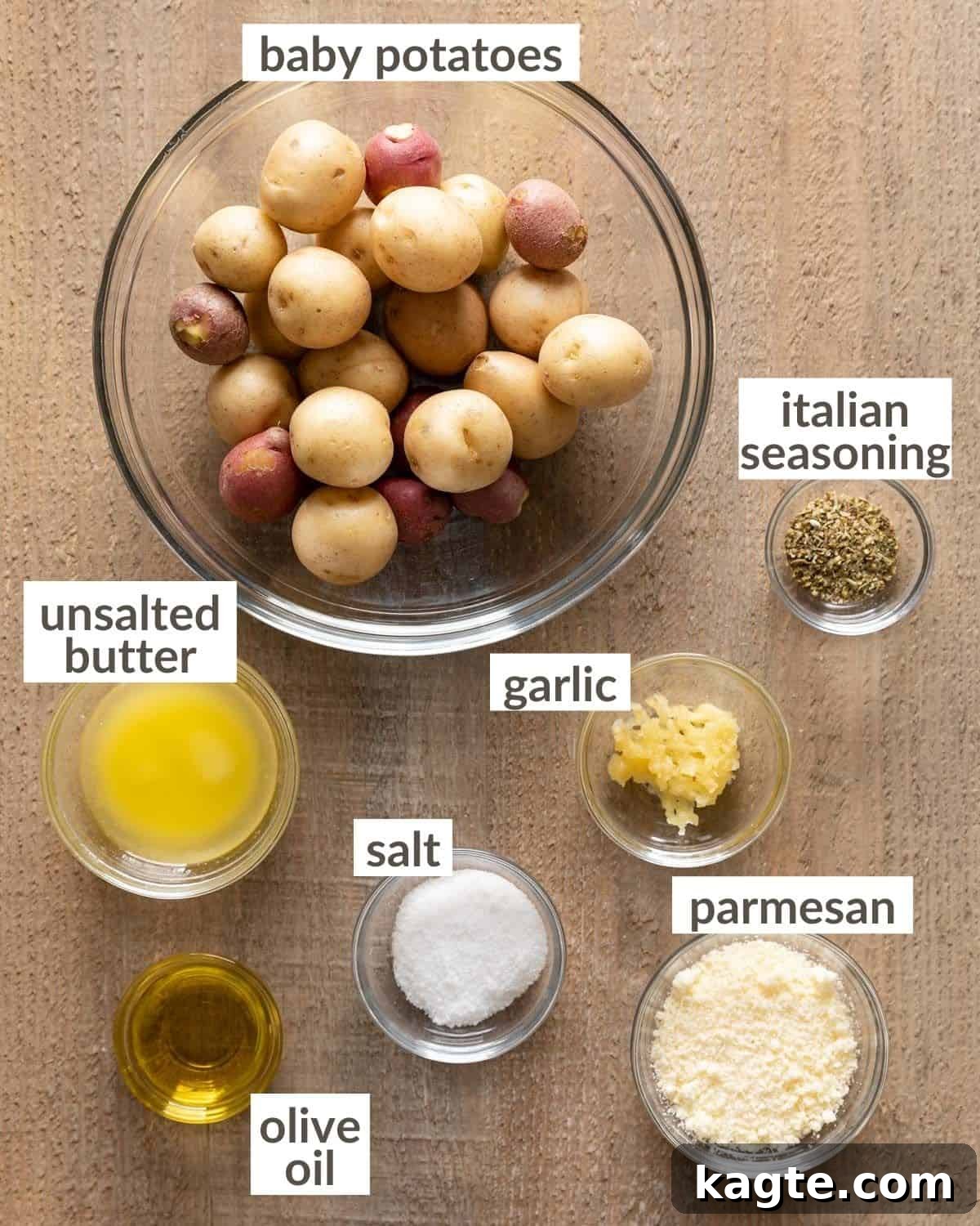 Golden Smashed Air Fryer Potatoes 3 Overhead view of all ingredients for air fryer smashed potatoes laid out on a countertop, including small potatoes, olive oil, butter, parmesan, garlic, and herbs.