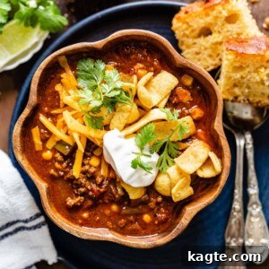 Instant Pot Chili (No Beans) in a bowl, garnished with sour cream and fresh herbs