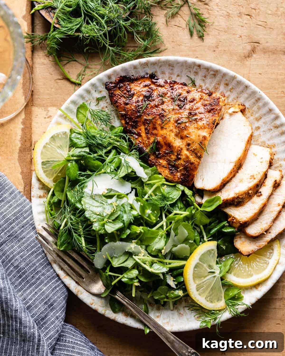 Overhead image of air fryer frozen chicken breasts with side salad. 