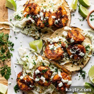 Finished Air Fryer Shrimp Tacos served on a plate with fresh lime wedges and cilantro, ready to be enjoyed.