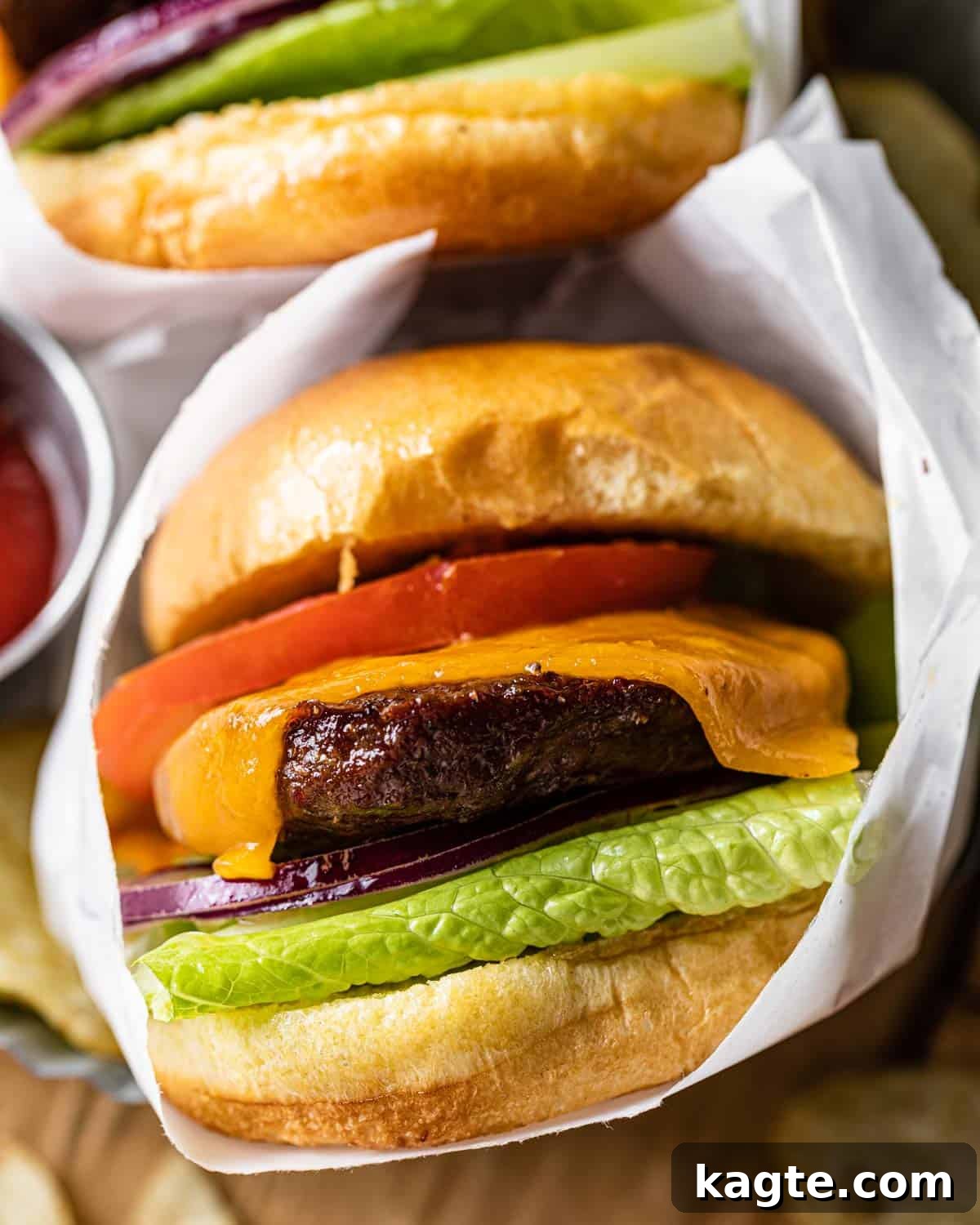 From Frozen to Fabulous: Air Fryer Hamburger Patties 7 Up close image of burger with toppings wrapped in white paper.