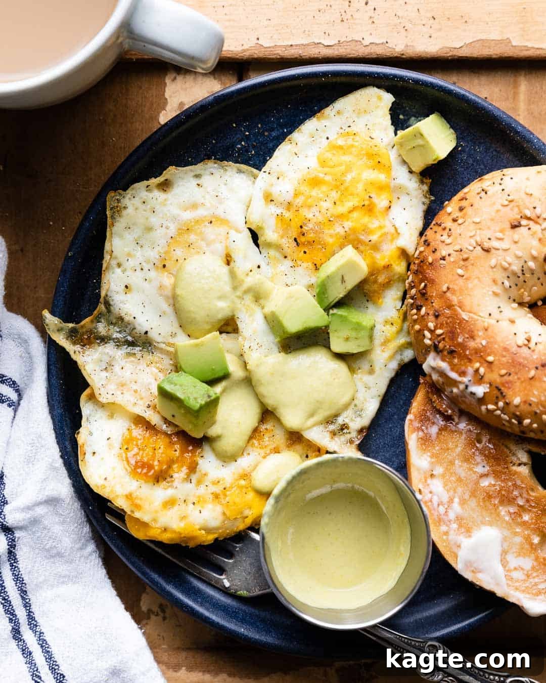 Solid Gold Yolks 2 Fried eggs over hard with avocado, hot sauce, and a bagel, ready to be enjoyed as a hearty breakfast or brunch.