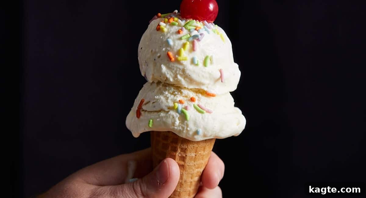 A close-up shot of creamy vanilla ice cream, possibly with specks of vanilla bean, scooped into a bowl or cone.