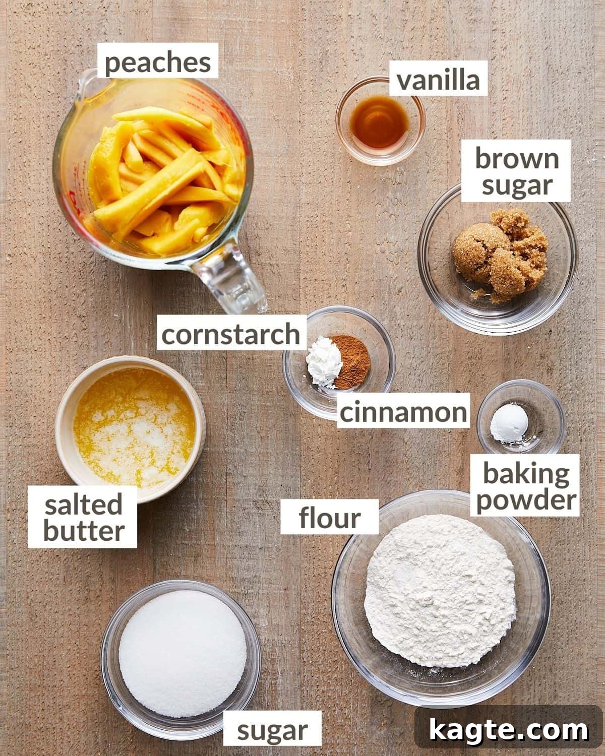 Overhead shot of fresh ingredients for air fryer peach cobbler, including thinly sliced peaches, all-purpose flour, granulated sugar, melted butter, brown sugar, cinnamon, and vanilla, neatly arranged in various glass bowls.