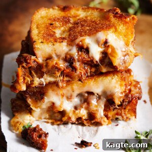 A delicious leftover Bolognese sandwich, cut in half and ready to eat.