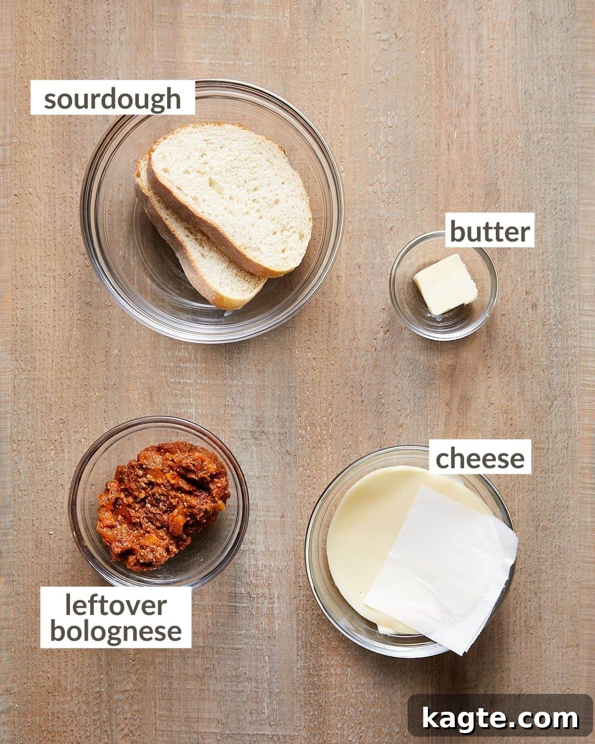 Hearty Bolognese Hero 3 Assorted ingredients for a bolognese sandwich laid out in glass bowls, including bread, cheese, butter, and bolognese.