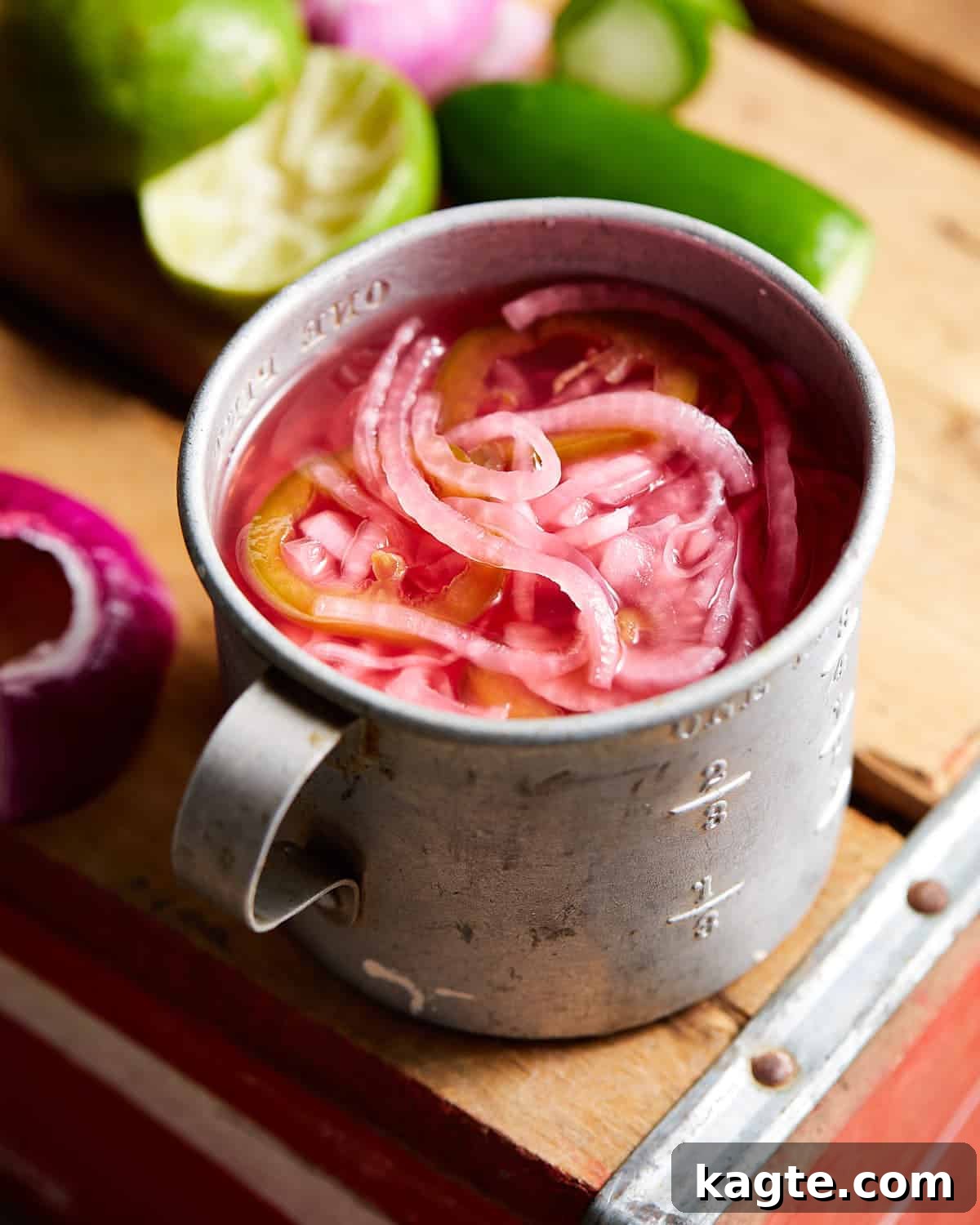 Zesty Mexican Pickled Onions 2 A close-up shot of bright pink Mexican pickled onions in a rustic metal cup, ready to be served.