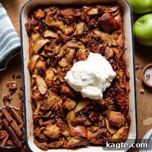 A warm slice of Apple Bread Pudding with melted caramel sauce and whipped cream.