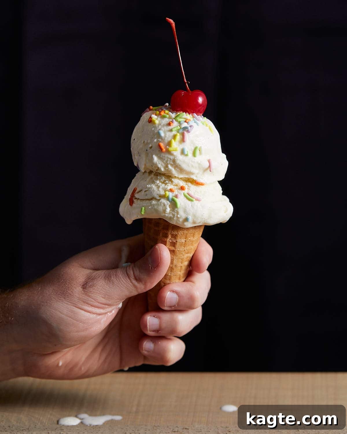 Homemade Eggless Vanilla Ice Cream 2 Vanilla ice cream without eggs in a corn with a cherry on top.