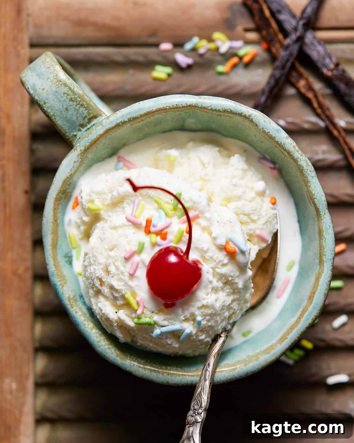 Homemade Eggless Vanilla Ice Cream 7 No egg vanilla ice cream in a mug with sprinkled and a cherry.