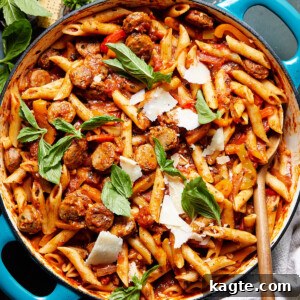 Easy Sausage and Peppers Pasta in a bowl, garnished with fresh basil and parmesan cheese.