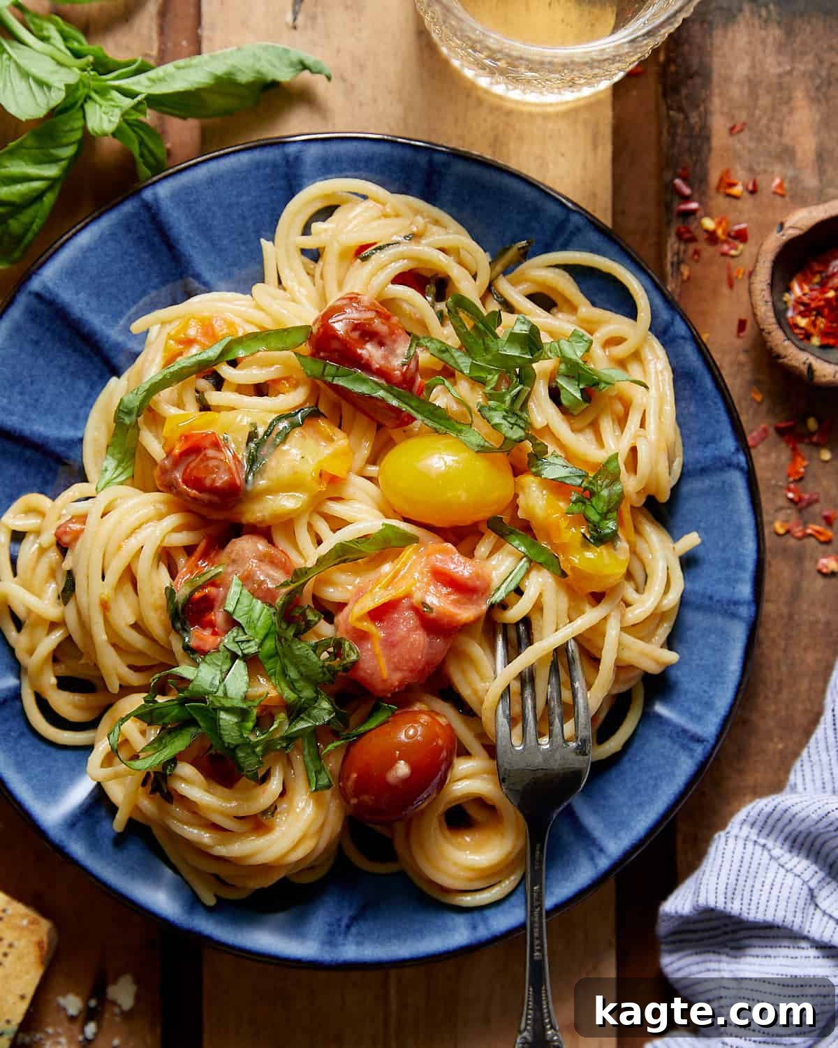 Vibrant Basil and Sweet Cherry Tomato Pasta 2 A beautifully presented bowl of basil pasta with cherry tomatoes on a rustic blue plate, garnished with fresh basil leaves, ready to be enjoyed.