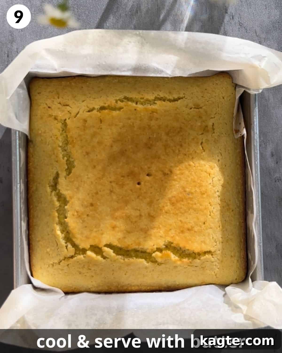 A freshly baked golden cornbread, still in its pan, removed from the oven and cooling.