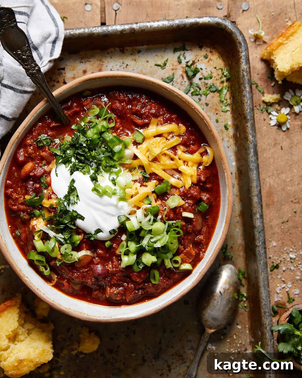 Cast-Iron Comfort Chili 2 A vibrant bowl of hearty Dutch oven chili, garnished generously with shredded cheese and a dollop of cool sour cream, inviting to a comforting meal.