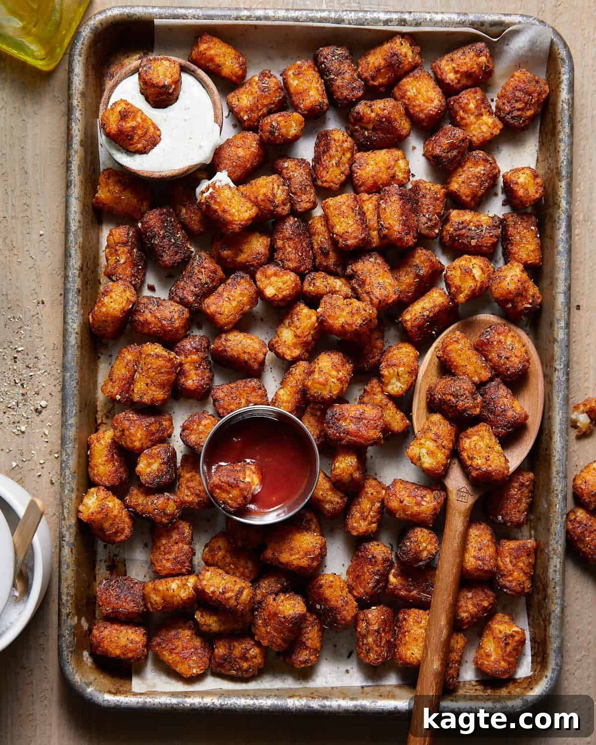 Crispy seasoned tater tots on a baking sheet, fresh out of the oven.