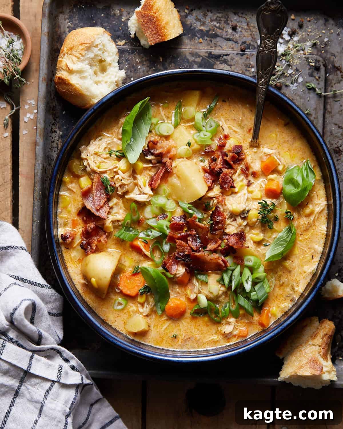 Hearty Slow Cooker Creamy Chicken Corn Chowder 2 A vibrant blue bowl filled with Slow Cooker Creamy Chicken and Corn Soup, garnished with fresh green herbs and crispy bacon bits, ready to be savored.