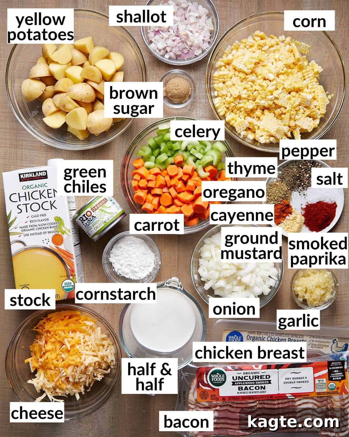 Hearty Slow Cooker Creamy Chicken Corn Chowder 3 A collection of fresh ingredients for slow cooker creamy chicken and corn soup, including ears of corn, small potatoes, carrots, celery, onions, garlic, and seasoning blend, arranged neatly.