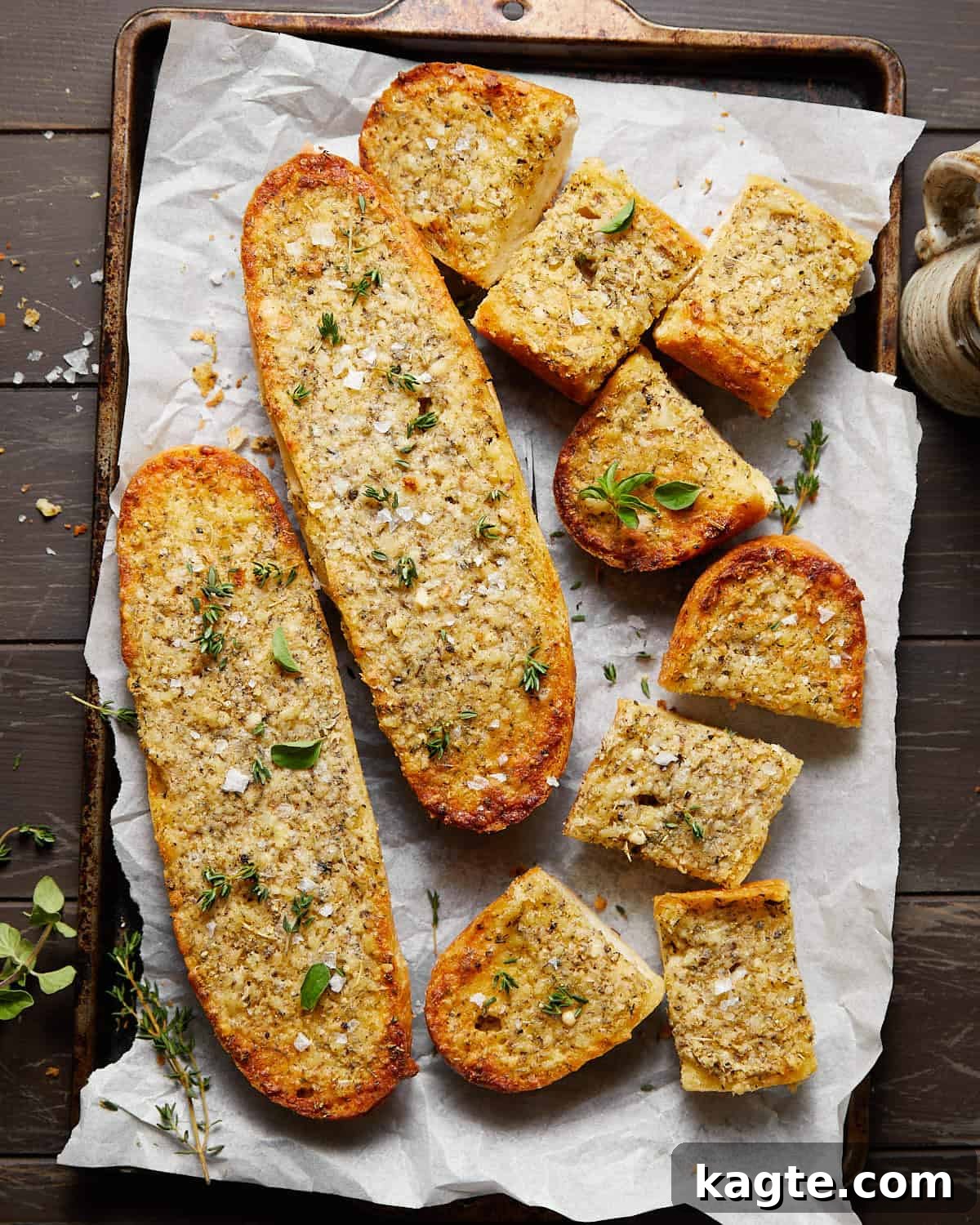 Delicious image of freshly made garlic bread spread with a hint of garnish, ready to be baked.
