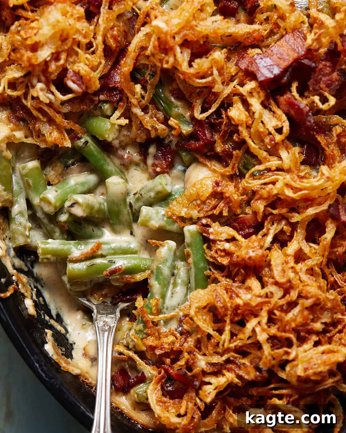 Savory Green Bean Casserole with Bacon and Earthy Mushrooms 7 Up close image of the texture and layers of green bean casserole with bacon and mushrooms, topped with crispy onions.