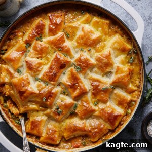 Close-up image of a single-serving chicken pot pie with puff pastry, showing the flaky golden crust and a glimpse of the creamy filling.