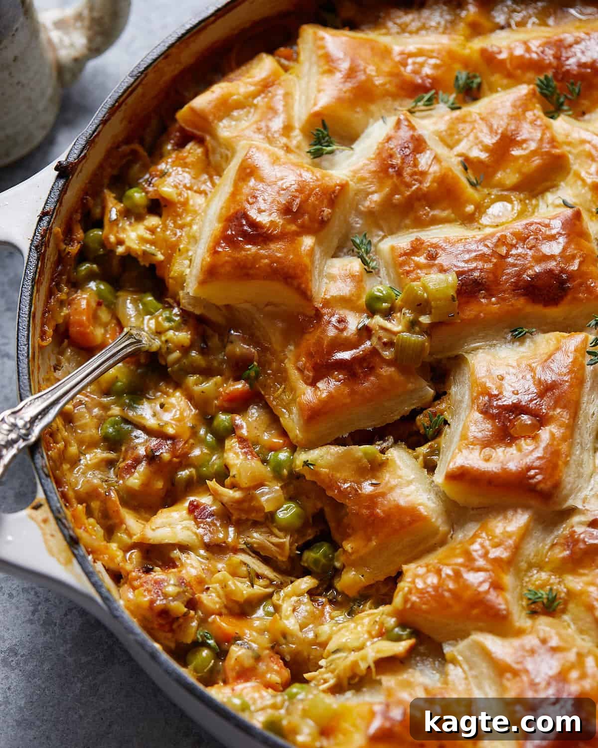 Golden Flaky Chicken Pot Pie 7 Up close image of chicken pot pie with puff pastry showing the flaky layers of the golden crust and the creamy filling underneath.