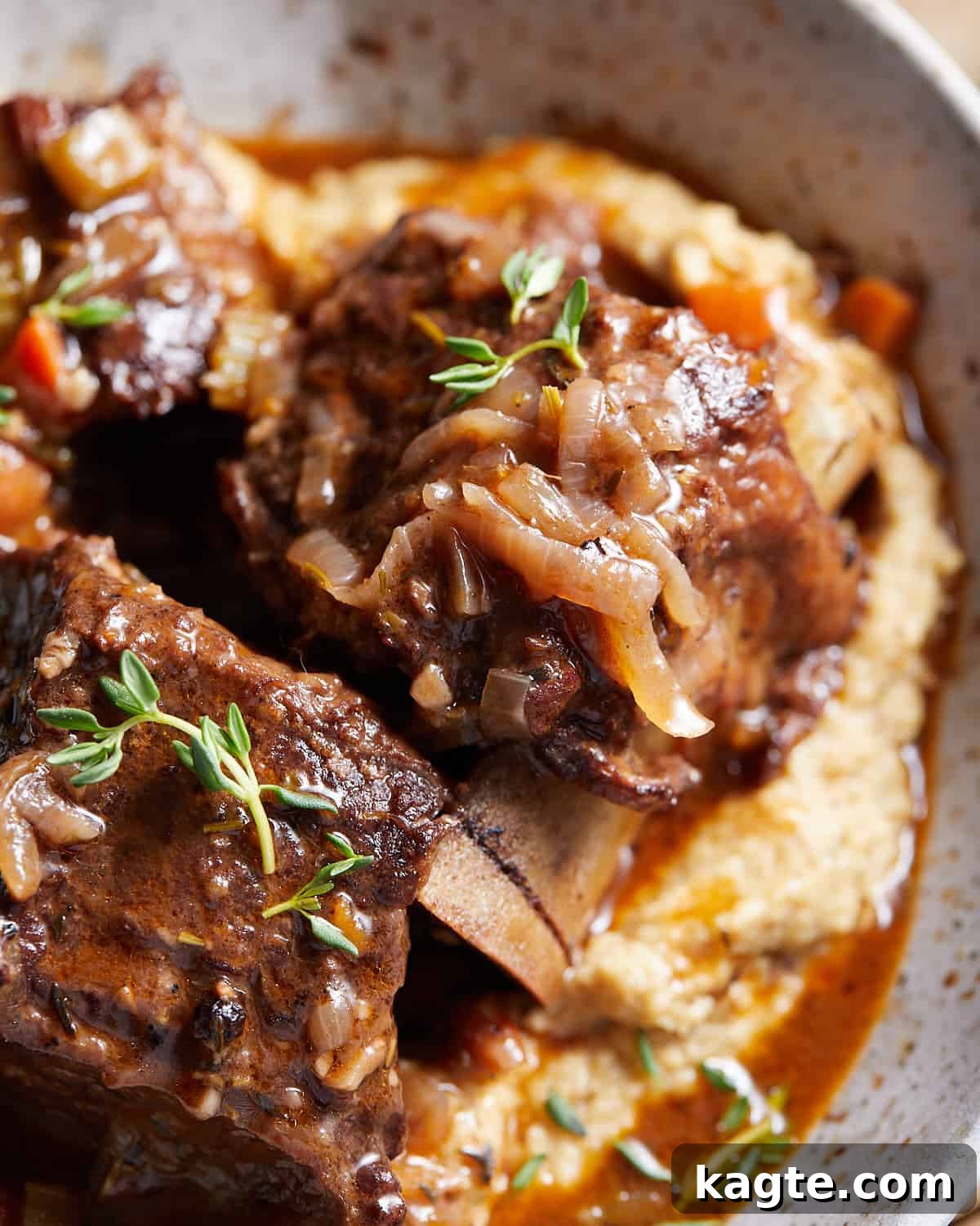 Slow-Braised Red Wine Short Ribs 6 Up close image of red wine short ribs with garnish of fresh herbs.