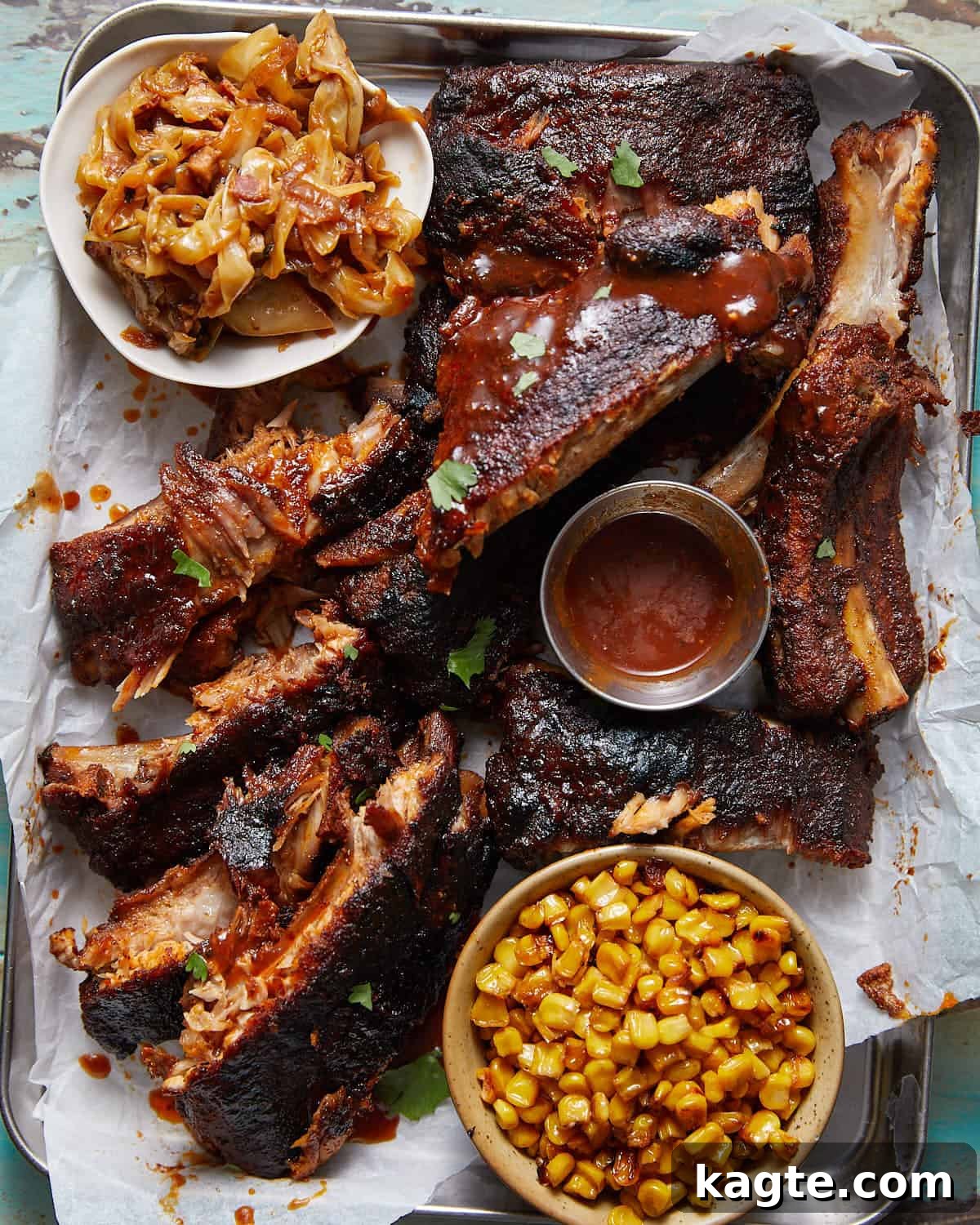 Fall-Off-The-Bone Oven Ribs 2 Overhead image of baby back ribs with side dishes and sauce.