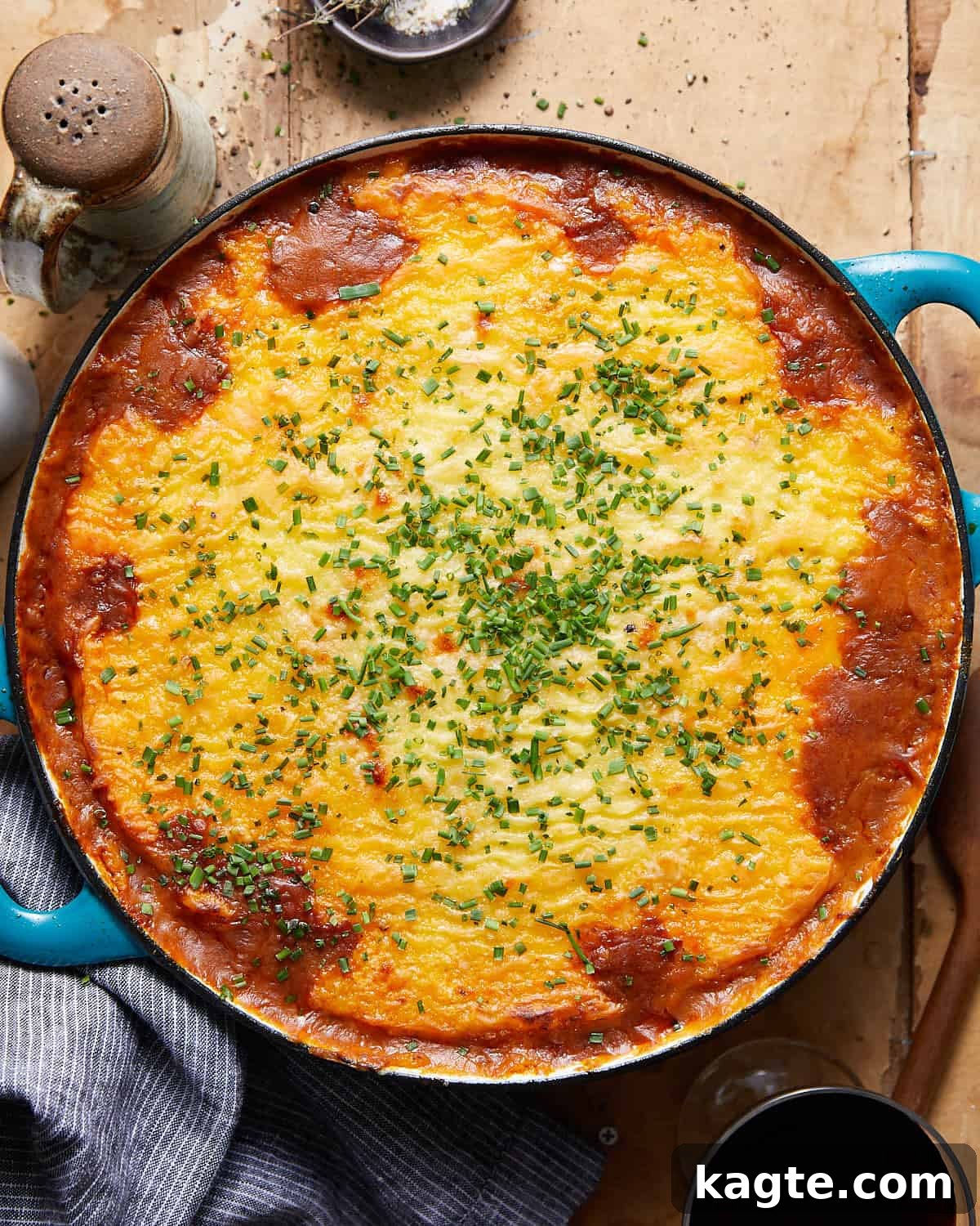 Rustic Dutch Oven Shepherd's Pie 2 Overhead image of a beautifully baked Dutch Oven Shepherd's Pie in a blue dish, garnished and ready to serve.
