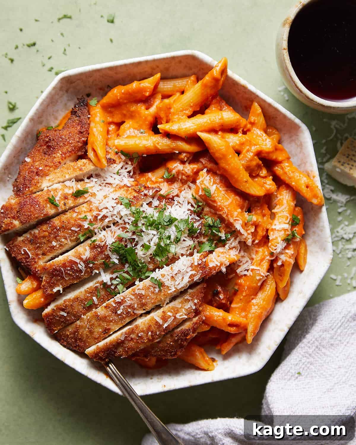 Overhead image of penne alla vodka with chicken in white dish with garnish. 