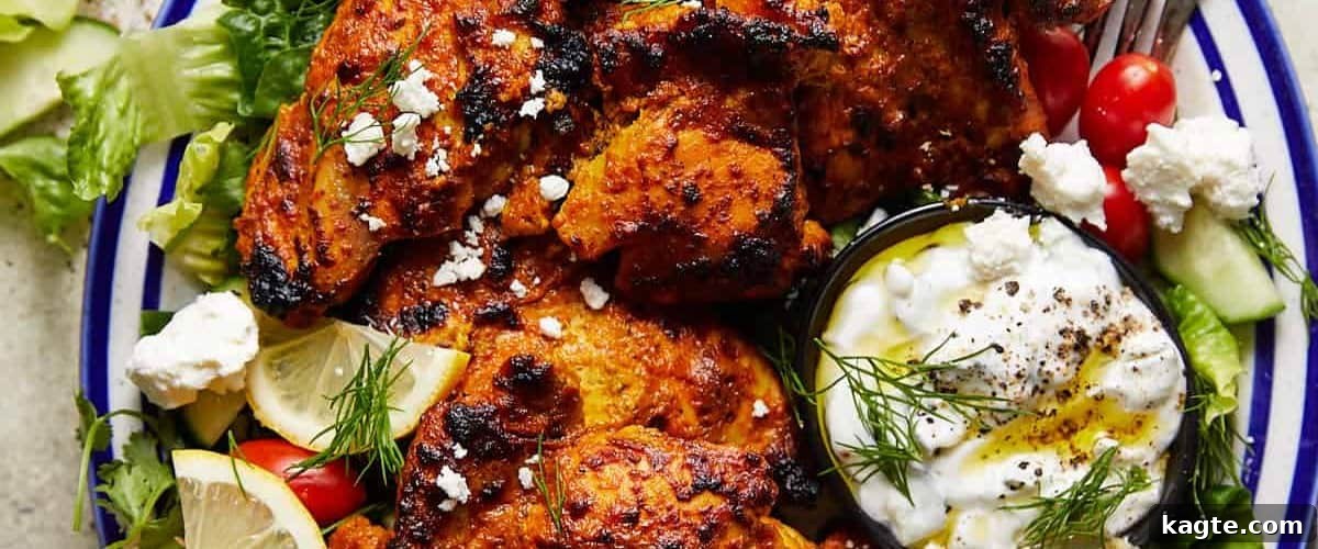 25 Hassle-Free Boneless Chicken Thigh Ideas 6 Greek yogurt chicken presented beautifully on a white and blue plate, garnished with fresh herbs.