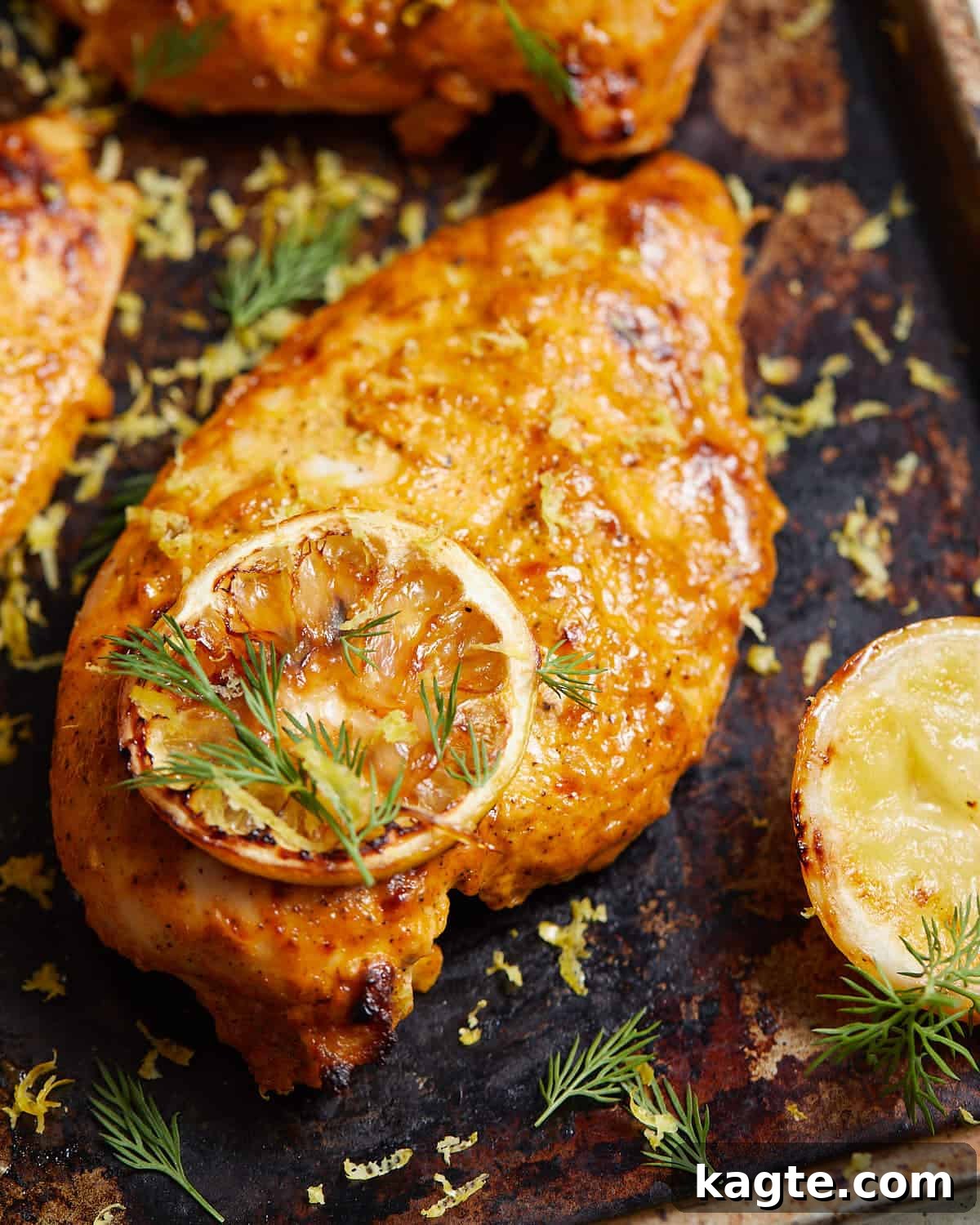 Close-up overhead image of perfectly cooked lemon chicken with fresh garnish.